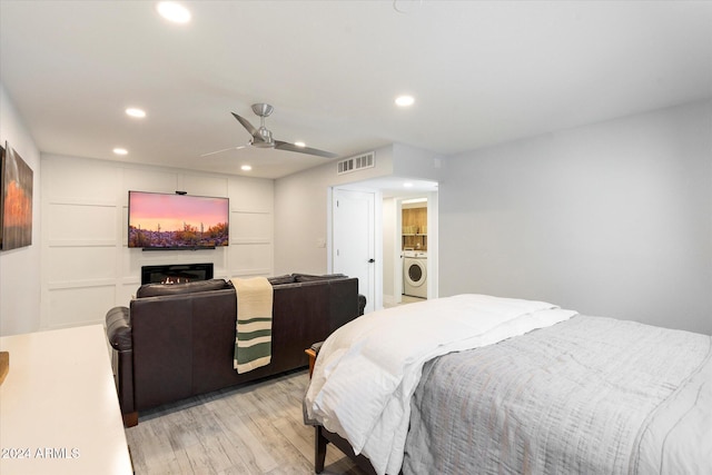 bedroom featuring washer / clothes dryer, ceiling fan, and light wood-type flooring