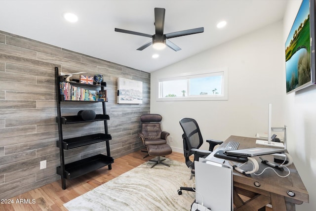 office featuring hardwood / wood-style flooring, vaulted ceiling, wooden walls, and ceiling fan