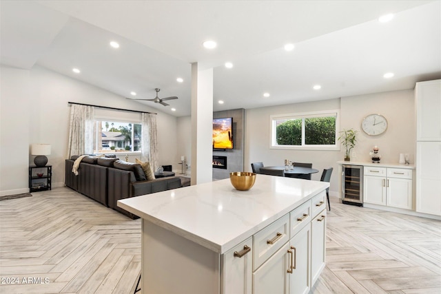 kitchen with white cabinetry, beverage cooler, light parquet flooring, and a kitchen island