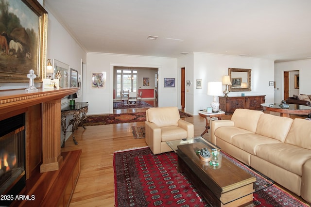 19125 N Lower Territory Rd, Prescott, AZ 86305 - living room featuring crown molding, light wood finished floors, and a warm lit fireplace