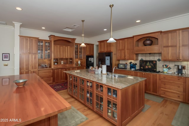 19125 N Lower Territory Rd, Prescott, AZ 86305 - kitchen with black fridge with ice dispenser, brown cabinets, a large island with sink, open shelves, and ornamental molding