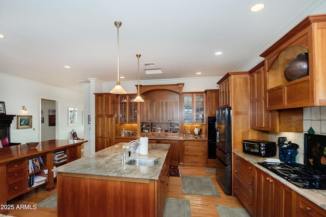 19125 N Lower Territory Rd, Prescott, AZ 86305 - kitchen featuring black appliances, brown cabinets, light wood-style floors, an island with sink, and tasteful backsplash