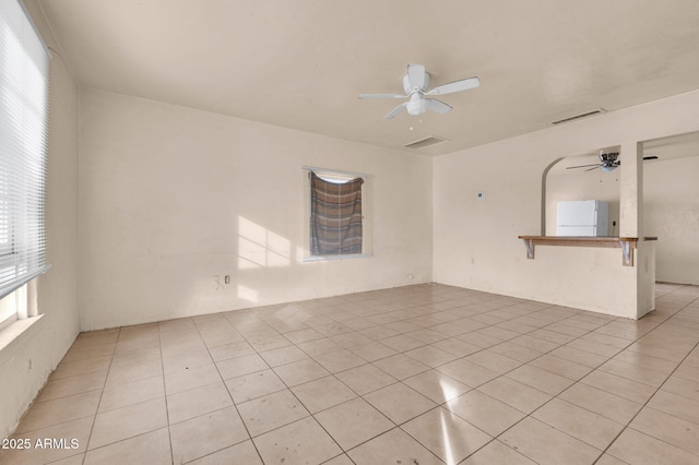 tiled spare room featuring ceiling fan