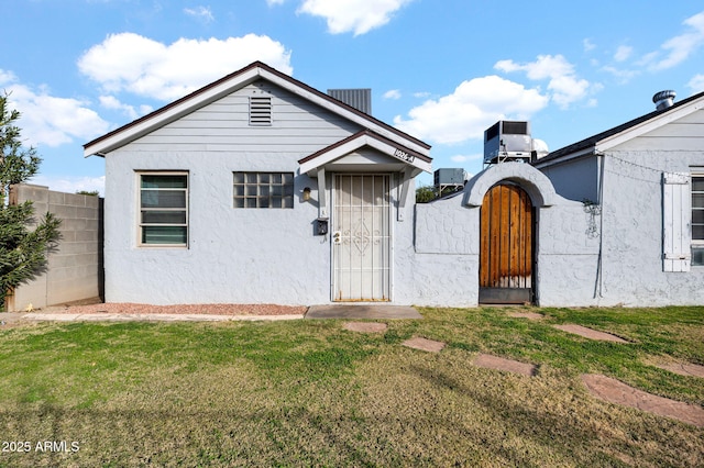 view of front of property with a front lawn and cooling unit