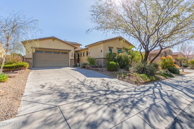 view of front facade featuring stucco siding, driveway, stone siding, a garage, and a tiled roof