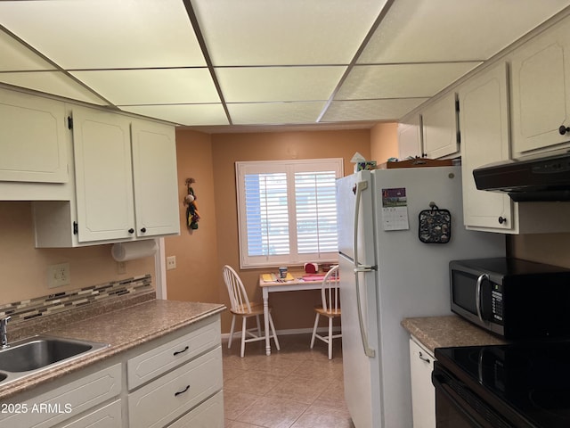 kitchen featuring sink, white cabinetry, stove, light tile patterned flooring, and a drop ceiling