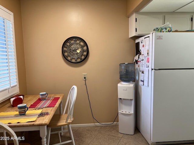 kitchen featuring light tile patterned flooring, white cabinets, and white refrigerator