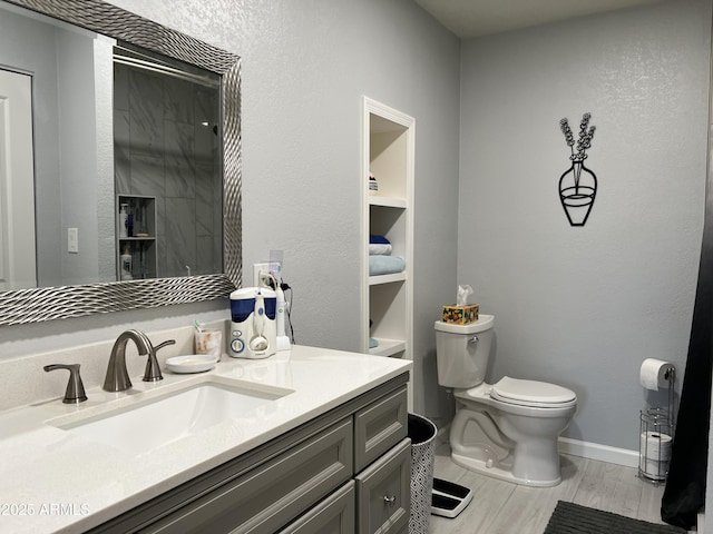 bathroom with vanity, toilet, and wood-type flooring