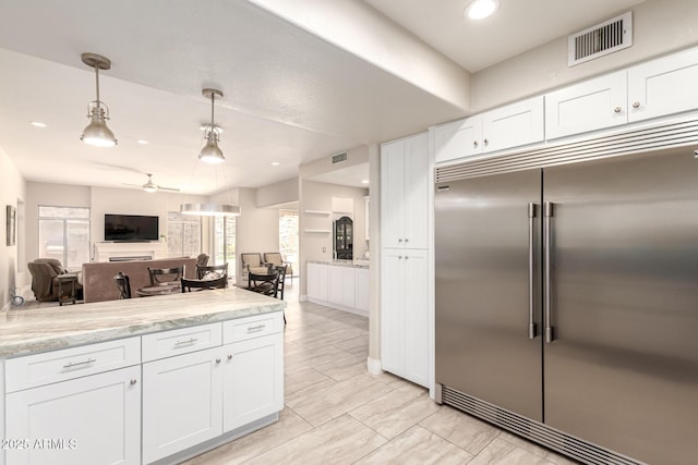 14058 S 24th Way, Phoenix, AZ 85048 - kitchen with built in fridge, open floor plan, white cabinetry, a ceiling fan, and decorative light fixtures