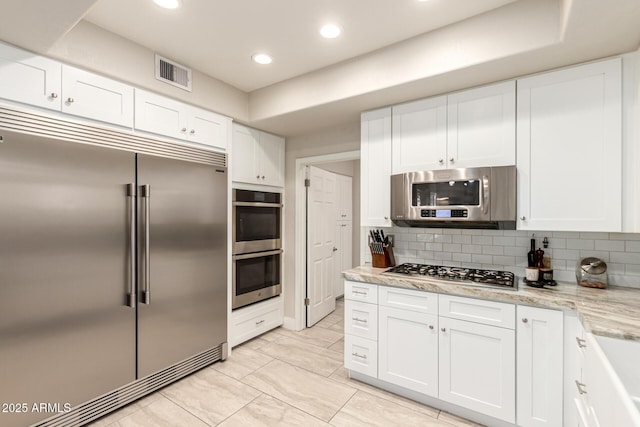 14058 S 24th Way, Phoenix, AZ 85048 - kitchen with appliances with stainless steel finishes, white cabinetry, tasteful backsplash, recessed lighting, and light stone counters