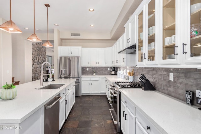 kitchen with sink, white cabinetry, decorative backsplash, stainless steel appliances, and decorative light fixtures