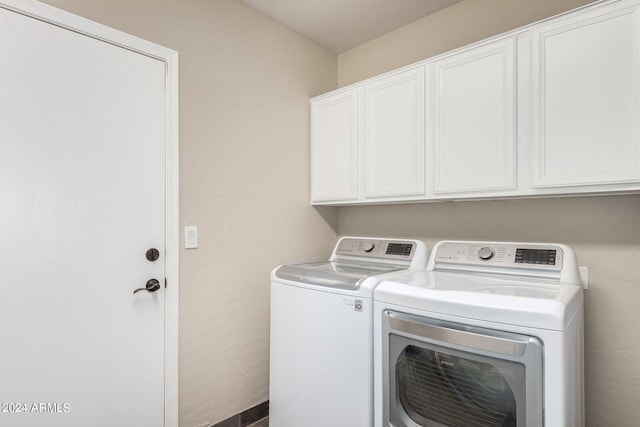 laundry area with separate washer and dryer and cabinets