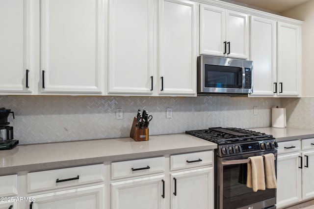 kitchen featuring backsplash, white cabinetry, and stainless steel appliances