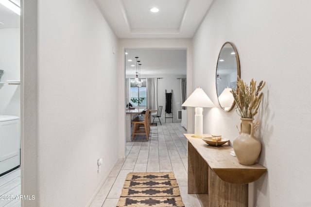 corridor featuring recessed lighting, a tray ceiling, and wood tiled floor