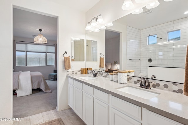 full bathroom featuring a sink, decorative backsplash, walk in shower, and double vanity