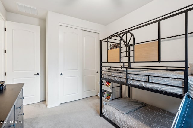 bedroom featuring carpet flooring, visible vents, and a closet