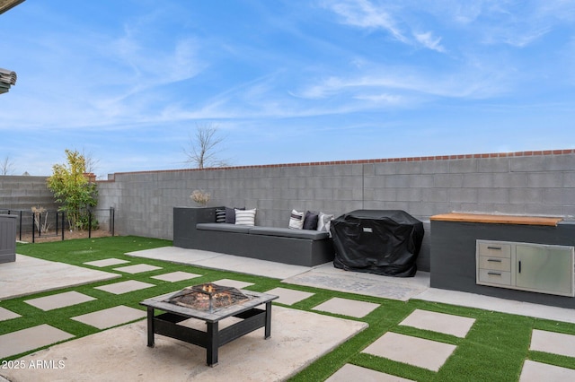 view of yard featuring an outdoor living space with a fire pit, a fenced backyard, and a patio area