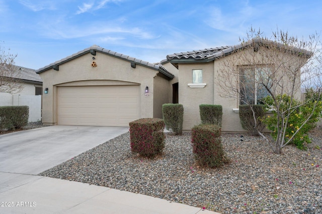 view of front of property with a tile roof, stucco siding, concrete driveway, and a garage