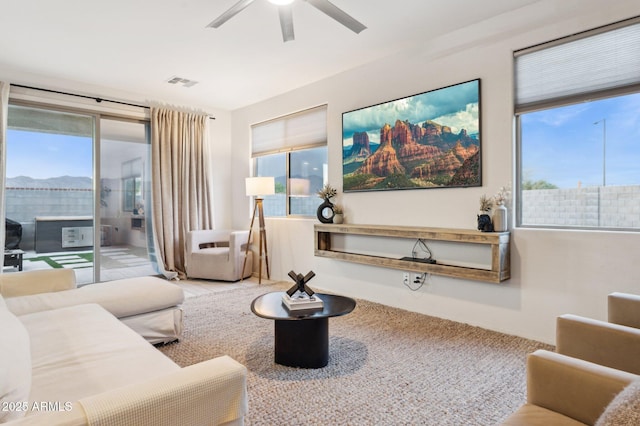 living area featuring visible vents and ceiling fan