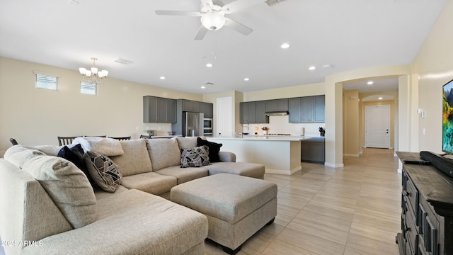 living room with ceiling fan with notable chandelier and light tile patterned flooring