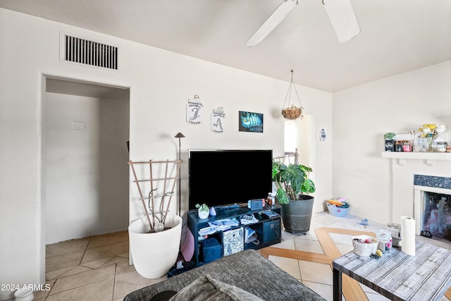 living room with ceiling fan, light tile patterned floors, and a premium fireplace