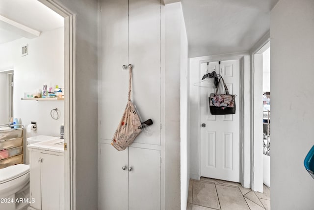 bathroom with toilet, vanity, and tile patterned floors