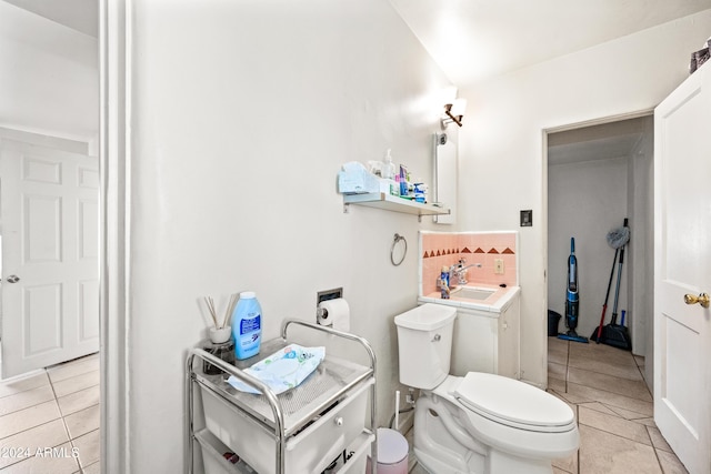 bathroom with toilet, vanity, and tile patterned floors