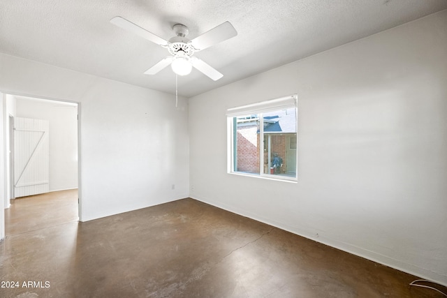 spare room with ceiling fan, concrete flooring, and a textured ceiling