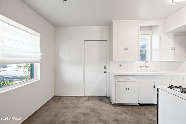 kitchen featuring white cabinets, plenty of natural light, sink, and tasteful backsplash