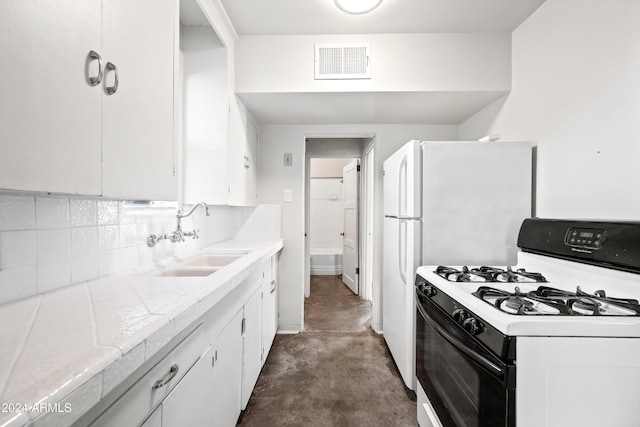 kitchen featuring white gas range, white cabinetry, sink, backsplash, and tile countertops