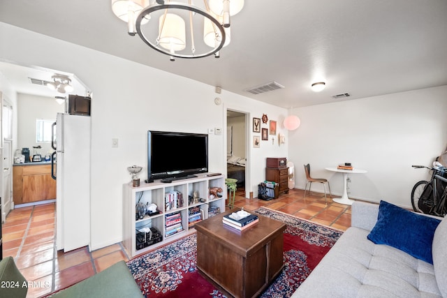 living room with tile patterned flooring and a notable chandelier