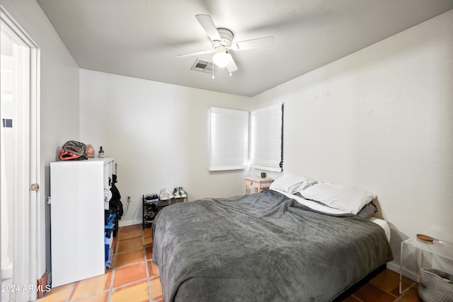 tiled bedroom featuring ceiling fan