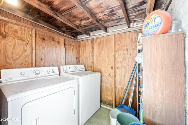 washroom with wood walls and washer and clothes dryer