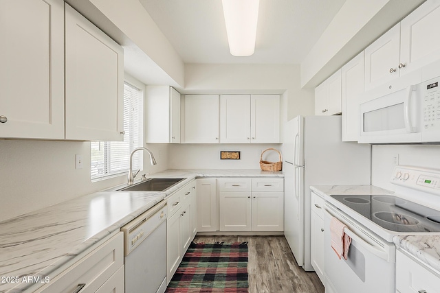 4554 E Paradise Village Pkwy N Unit 249, Phoenix, AZ 85032 - kitchen with white appliances, a sink, light stone counters, light wood finished floors, and white cabinets