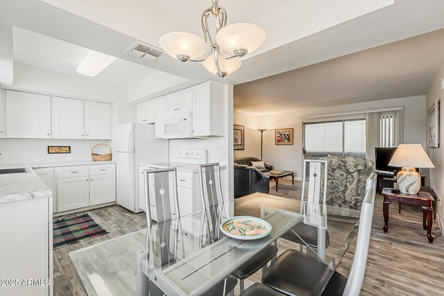 4554 E Paradise Village Pkwy N Unit 249, Phoenix, AZ 85032 - dining room with washer / clothes dryer, a notable chandelier, light wood-style floors, and visible vents