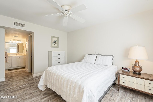 4554 E Paradise Village Pkwy N Unit 249, Phoenix, AZ 85032 - bedroom with a sink, visible vents, wood finished floors, and ensuite bath