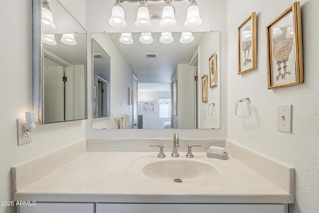 4554 E Paradise Village Pkwy N Unit 249, Phoenix, AZ 85032 - bathroom with vanity, a textured wall, and visible vents