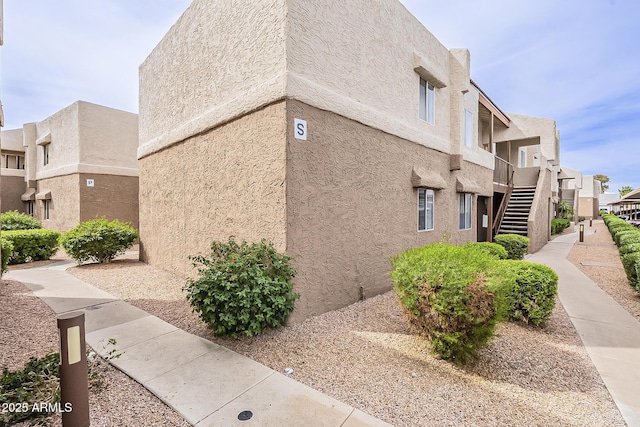 4554 E Paradise Village Pkwy N Unit 249, Phoenix, AZ 85032 - view of side of home featuring stucco siding and stairs