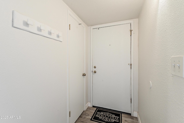 4554 E Paradise Village Pkwy N Unit 249, Phoenix, AZ 85032 - doorway with a textured wall, baseboards, and wood finished floors