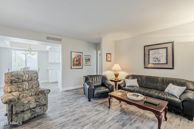 4554 E Paradise Village Pkwy N Unit 249, Phoenix, AZ 85032 - living room featuring baseboards, visible vents, light wood-style floors, and a notable chandelier