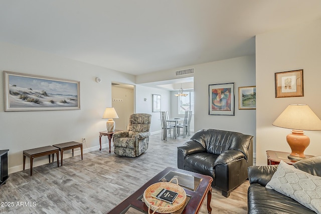 4554 E Paradise Village Pkwy N Unit 249, Phoenix, AZ 85032 - living room featuring light wood-type flooring, a notable chandelier, baseboards, and visible vents