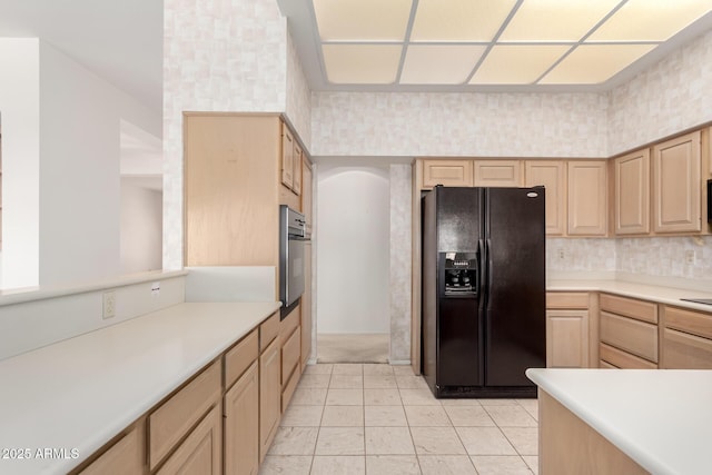 kitchen featuring light brown cabinets and black appliances