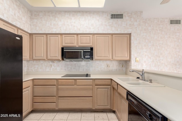 kitchen featuring light tile patterned flooring, sink, light brown cabinets, and black appliances