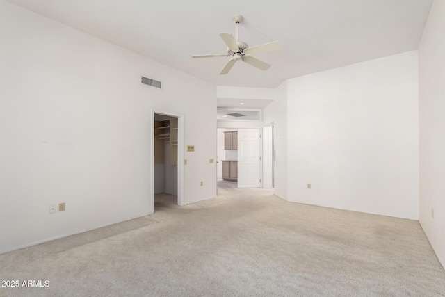 empty room with ceiling fan and light carpet