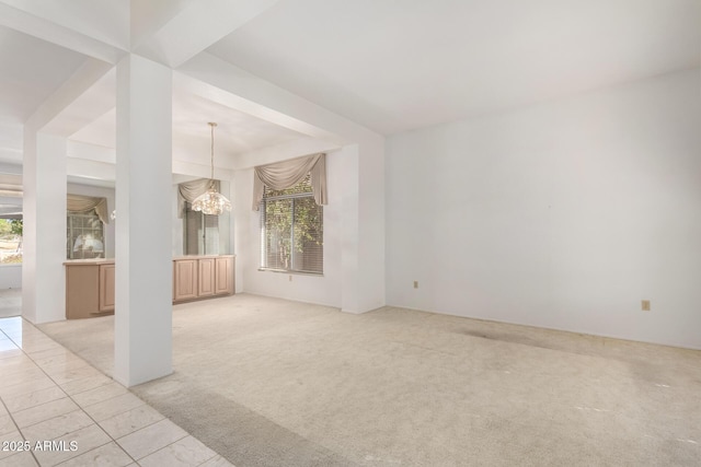 unfurnished living room featuring light carpet and a notable chandelier