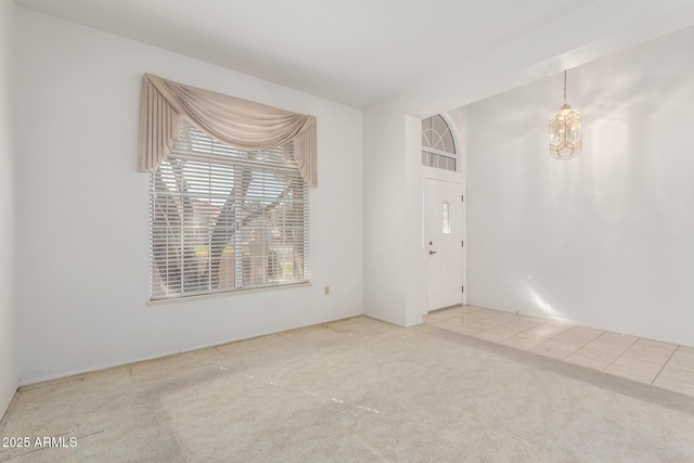 unfurnished room with carpet floors and a chandelier