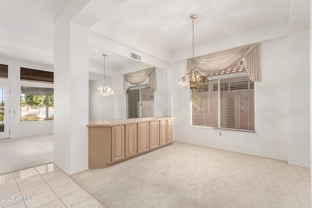 unfurnished dining area with light colored carpet and a chandelier