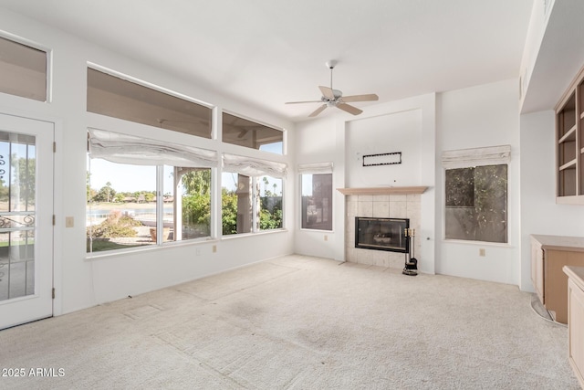 unfurnished living room featuring light carpet, a fireplace, and ceiling fan