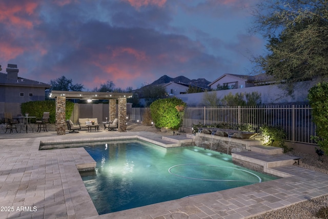 pool at dusk featuring outdoor lounge area, a patio, and pool water feature