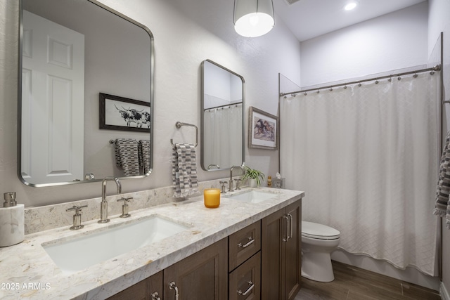 bathroom with hardwood / wood-style flooring, vanity, and toilet